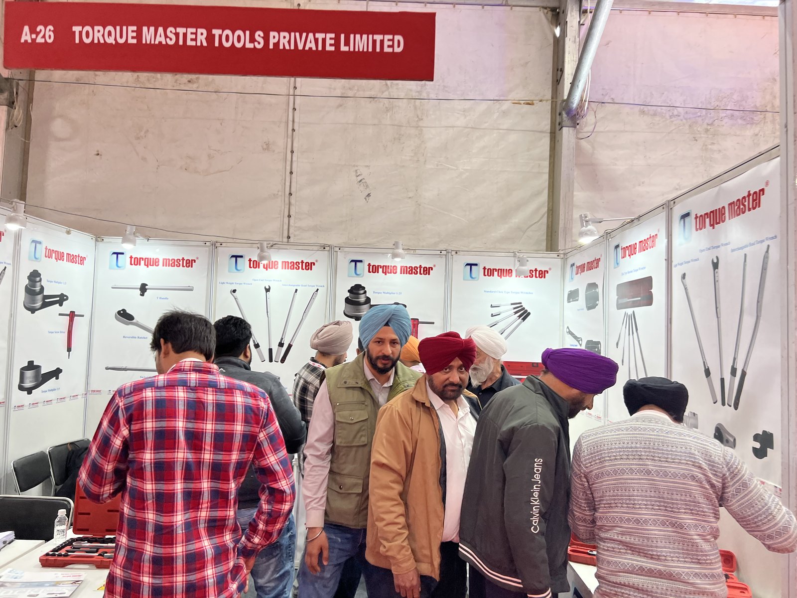 Torque Master Tools Private Limited stall A-26 at an expo in Ludhiana, 2025, with visitors viewing torque tool display panels